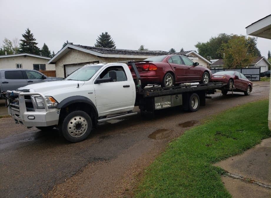 A flatbed truck collecting cars from an Edmonton home